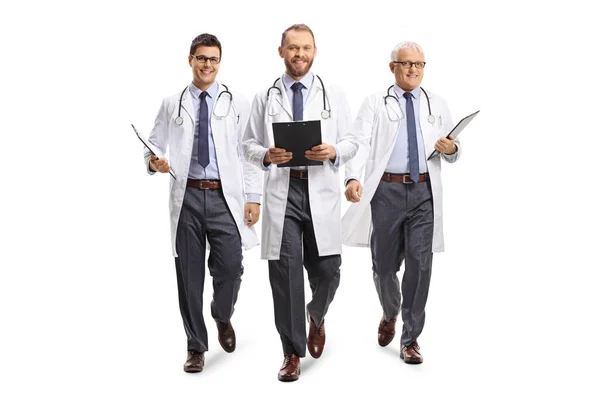 白い背景に隔離されたカメラに向かって笑顔と歩いている3人の男性医師 — ストック写真
