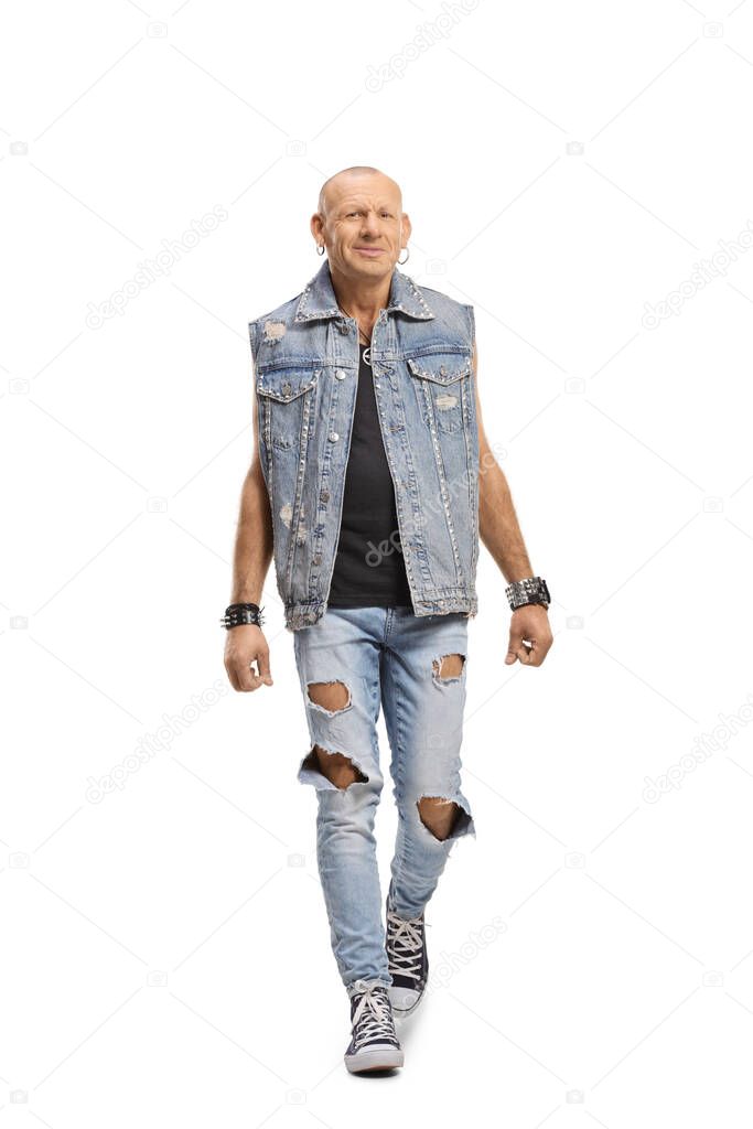 Bald man in a denim vest walking towards camera isolated on white background