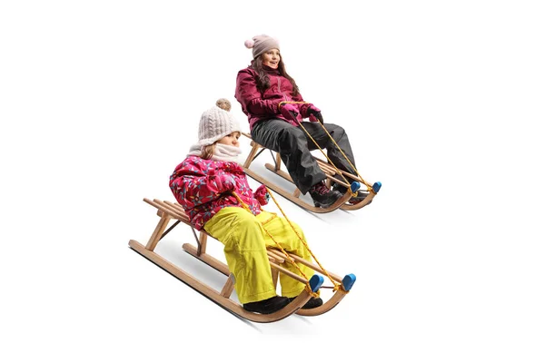 孩子们穿着白色背景的木制雪橇滑行 — 图库照片