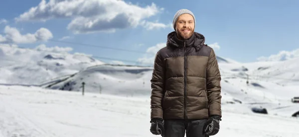 穿着冬衣和裤子站在雪山上的年轻人 — 图库照片