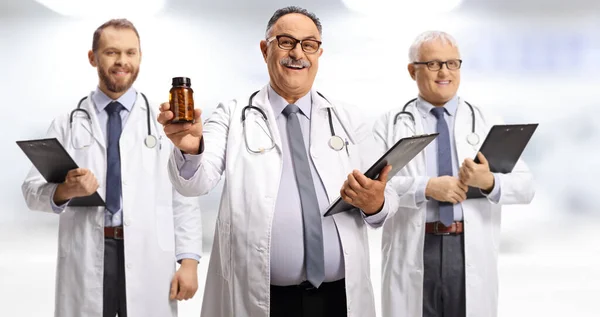 Tres Médicos Varones Sujetando Portapapeles Mostrando Una Botella Pastillas — Foto de Stock