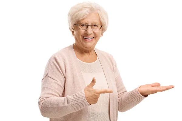 Uśmiechnięta Starsza Kobieta Wskazująca Pustą Dłoń Odizolowaną Białym Tle — Zdjęcie stockowe