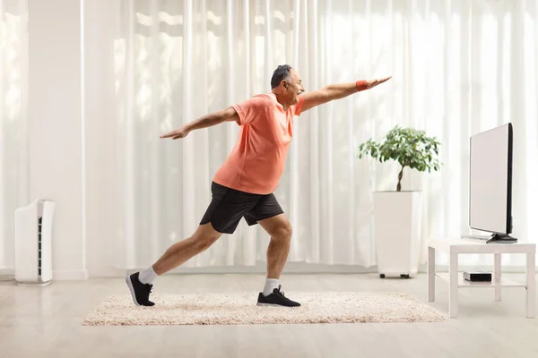 Yetişkin Bir Adamın Spor Giyim Kuşamında Evde Televizyon Karşısında Egzersiz — Stok fotoğraf