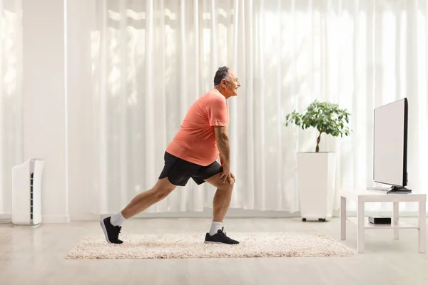 Full Längd Profil Skott Mogen Man Stretching Benet Framför Hemma — Stockfoto