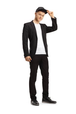 Moda kıyafetler giyen ve şapkasını beyaz arka planda tutan bir adamın tam boy portresi.