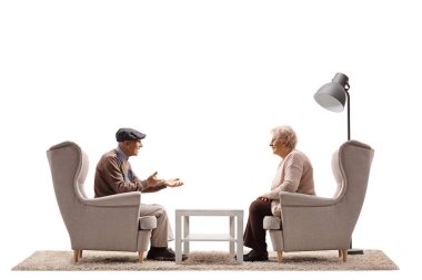 Yaşlı bir adam ve kadının oturduğu koltuklarda otururken ve beyaz arka planda izole bir şekilde konuşurken profil fotoğrafı.