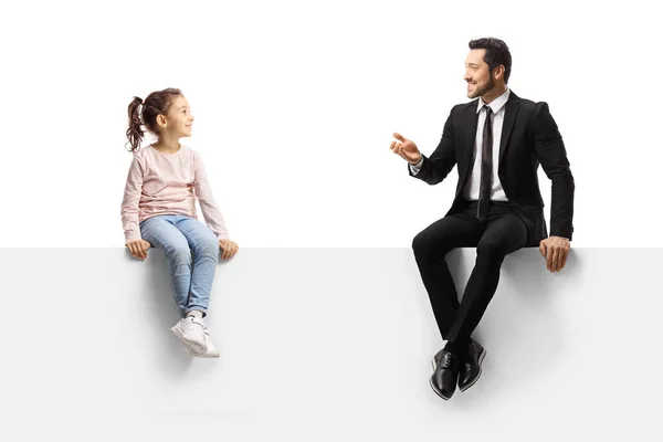 商人坐在一块空白的板子上 与一个被白色背景隔离的小女孩交谈 — 图库照片
