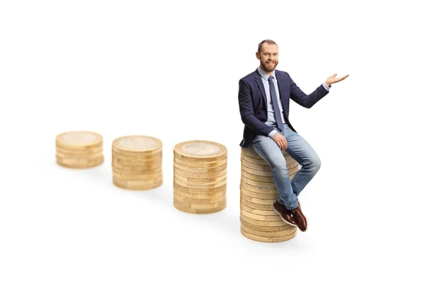 Young Professional Man Sitting Tallest Pile Coins Gesturing Hand Isolated — Stock Photo, Image