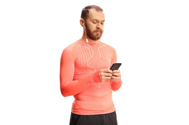 Kulaklıklı bir erkek koşucu beyaz arka planda izole edilmiş bir akıllı telefon tutuyor.