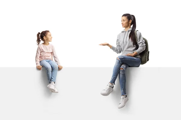 Estudante Feminina Sentada Painel Branco Conversando Com Uma Menina Isolada — Fotografia de Stock