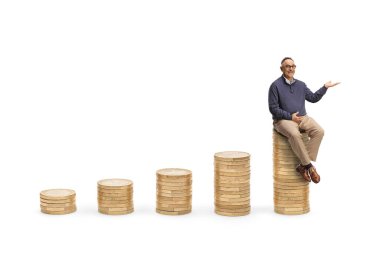 Olgun bir adam para yığınlarının üzerinde oturuyor ve beyaz arka planda elle izole edilmiş bir şekilde gösteriyor.