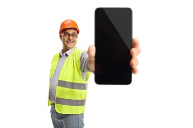 Yansıtıcı yelek giymiş neşeli erkek mühendis beyaz arka planda izole edilmiş bir akıllı telefon gösteriyor.