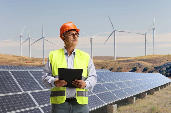 Gammal Manlig Ingenjör Stående Ett Fält Med Solpaneler Och Vindkraftverk — Stockfoto