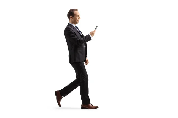 Full Length Profil Záběr Podnikatele Chůze Při Pohledu Smartphone Izolované — Stock fotografie