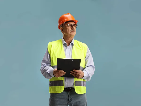 Volwassen Mannelijke Ingenieur Met Een Klembord Veiligheidsvest Kijken Naar Zijkant — Stockfoto