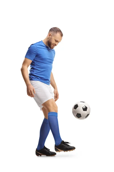 全长投篮一名身穿蓝色上衣和白色短裤的足球运动员踢打一个被白色背景隔开的球 — 图库照片