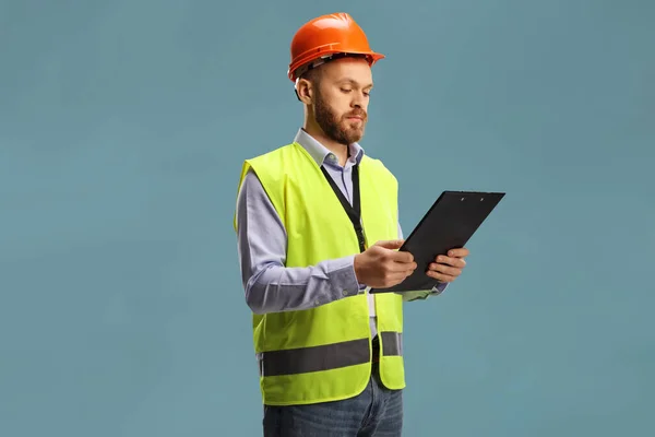 Male Engineer Wearing Reflective Vest Helmet Holding Clipboard Isolated Blue — Stock Photo, Image