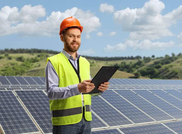 Joven Ingeniero Masculino Sosteniendo Documento Sobre Campo Energía Fotovoltaica Sostenible —  Fotos de Stock