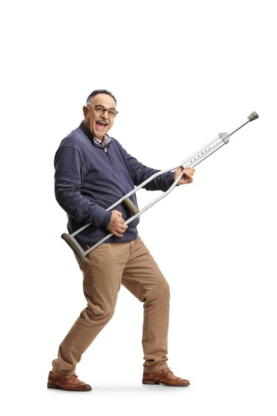 快乐成熟的男人用白色背景隔离的拐杖弹奏吉他 — 图库照片