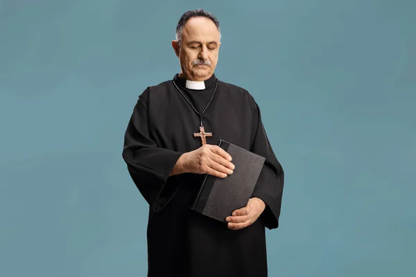 Rijpe Priester Met Een Bijbel Kijken Naar Beneden Geïsoleerd Blauwe — Stockfoto