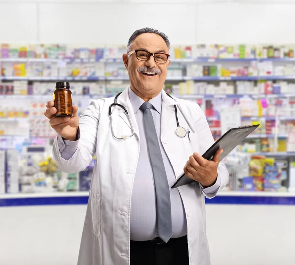 Mężczyzna Farmaceuta Trzymając Butelkę Tabletek Przed Ladą Apteki — Zdjęcie stockowe