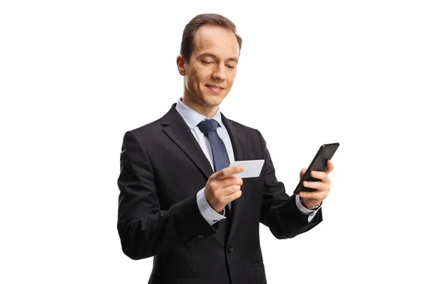 Бизнесмен Смотрит Кредитную Карту Держит Мобильный Телефон Изолирован Белом Фоне — стоковое фото