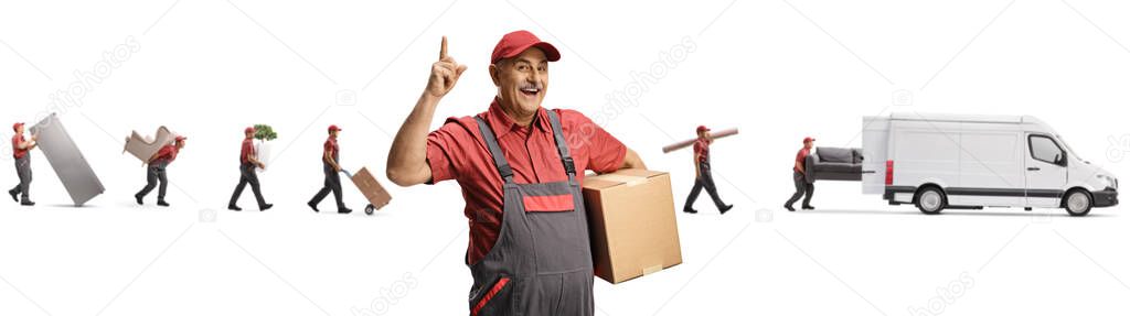 Cheerful mature mover pointing up and other movers putting household items in a van isolated on white background