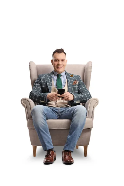 Hombre Sentado Sillón Sosteniendo Smartphone Mirando Cámara Aislada Sobre Fondo —  Fotos de Stock