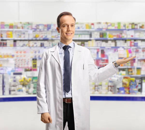 Farmacêutico Masculino Mostrando Com Mão Dentro Uma Farmácia — Fotografia de Stock