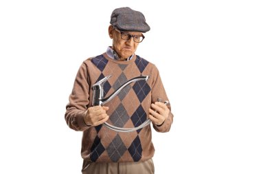 Beyaz arka planda su musluğu olan çelik bir hortum tutan yaşlı bir adam.