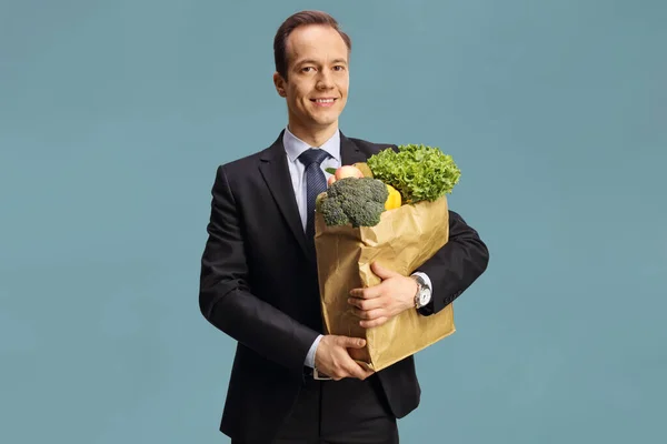 Empresario Sosteniendo Una Bolsa Papel Con Comestibles Sonriendo Aislado Sobre — Foto de Stock