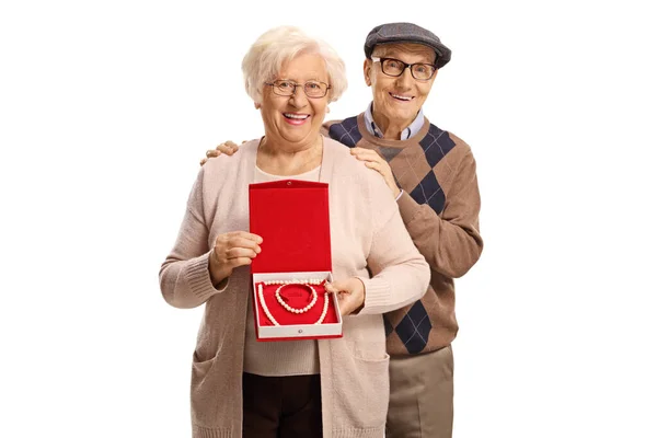 上了年纪的男人和女人手里拿着一个盒子 盒子里有一条珍珠项链和一个带白色背景的手镯 — 图库照片