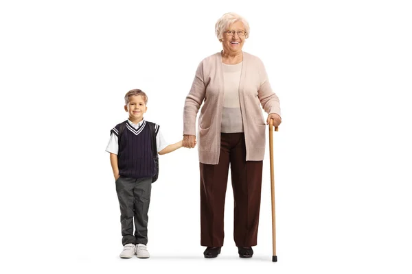 身穿校服的祖母和孙子的全长画像 他们站在那里 手挽手 双手被白色背景隔开 — 图库照片