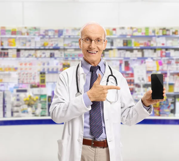 Homem Idoso Farmacêutico Mostrando Telefone Apontando Dentro Uma Farmácia — Fotografia de Stock