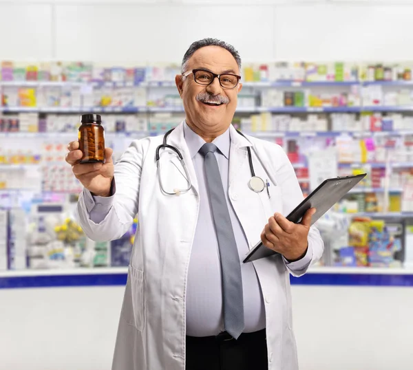 Uśmiechnięty Dojrzały Chemik Trzymający Butelkę Tabletek Aptece — Zdjęcie stockowe