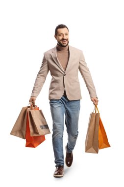 Alışveriş torbaları taşıyan ve beyaz arka planda izole bir şekilde kameraya doğru yürüyen bir adamın tam boy portresi.