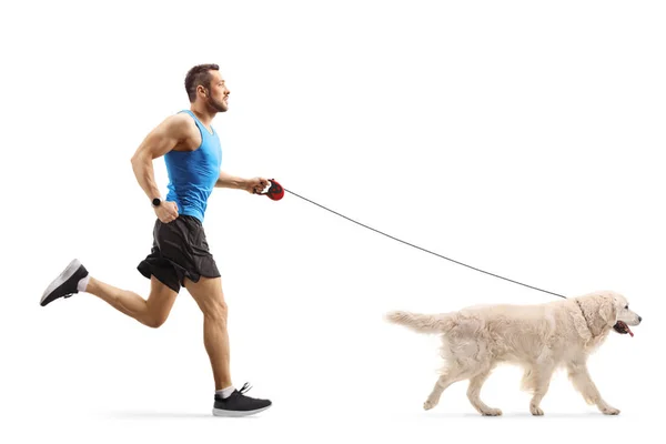 フル長さプロフィールショットの男ジョギングとともにリトリーバー犬孤立した上の白い背景 — ストック写真