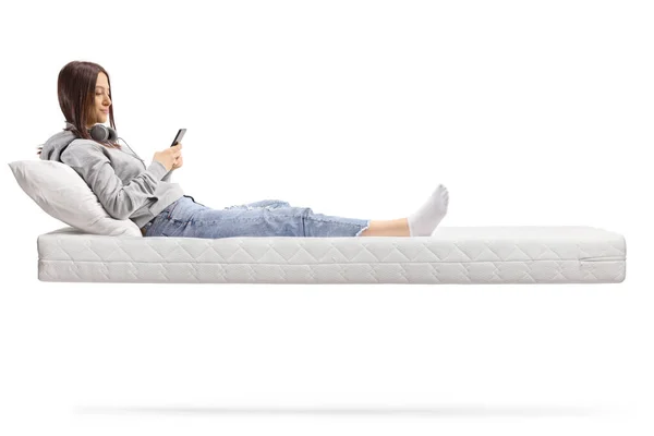 用白色背景隔离的智能手机在漂浮的床垫上的肥皂剧少年 — 图库照片