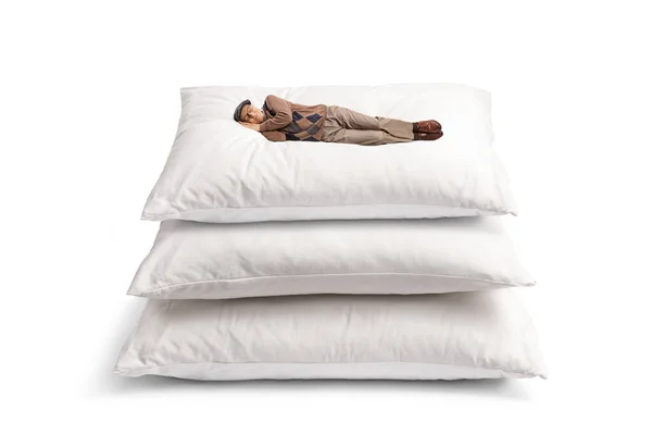 贪婪的人睡在一堆靠白色背景隔开的枕头上 — 图库照片
