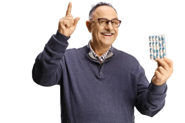 Starší Muž Drží Balíček Pilulek Ukazuje Nahoru Izolované Bílém Pozadí — Stock fotografie