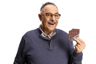 Çikolata tutan ve beyaz arka planda izole bir şekilde gülümseyen olgun adam.