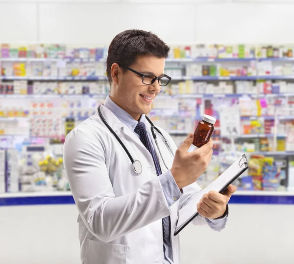 Farmacêutico Olhando Para Uma Garrafa Comprimidos Dentro Uma Farmácia — Fotografia de Stock