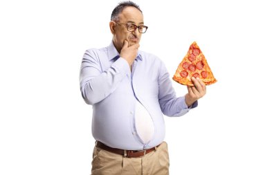 Dar tişörtlü dalgın olgun bir adam elinde beyaz arka planda izole edilmiş bir dilim pepperoni pizzası tutuyor.