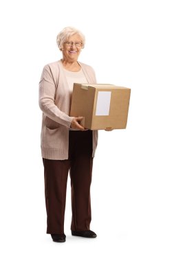 Beyaz arka planda karton bir kutu tutan yaşlı bir kadının tam boy portresi.