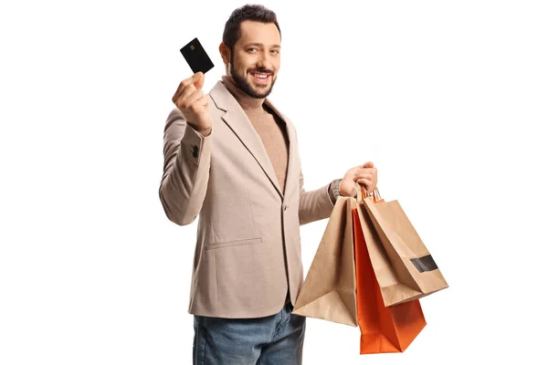 Hombre Mostrando Una Tarjeta Crédito Sosteniendo Bolsas Aisladas Sobre Fondo —  Fotos de Stock