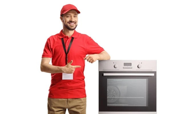 Mannelijke Winkel Assistent Met Een Oven Lachend Wijzend Geïsoleerd Witte — Stockfoto
