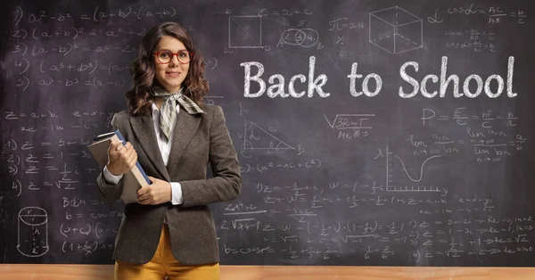 Young Female Teacher Holding Books Posing Front Chalkboard Text Back — Photo