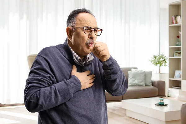 Uomo Maturo Casa Soggiorno Ridendo Tenendo Petto — Foto Stock