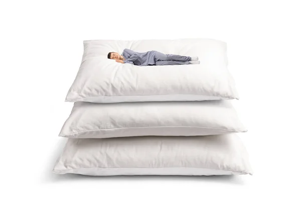 Beyaz Arka Planda Büyük Yastıkların Üzerinde Uyuyan Pijamalı Bir Adam — Stok fotoğraf
