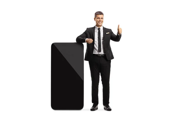 Man Suit Tie Leaning Big Mobile Phone Gesturing Thumb Sign — Stock Photo, Image